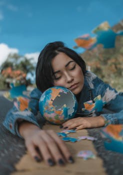 A woman relaxes outdoors with a globe puzzle, capturing a moment of peaceful daydreaming.
